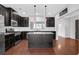 Spacious kitchen features an island, granite counters, stainless appliances, and hardwood flooring at 3490 Buffington Ln, Cumming, GA 30040