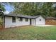 View of a backyard featuring a freshly painted white brick home with a concrete patio and a well-maintained lawn at 1934 Pinedale Pl, Decatur, GA 30032