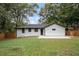 A spacious backyard featuring a freshly painted white brick home, a concrete patio, and a freshly cut lawn at 1934 Pinedale Pl, Decatur, GA 30032