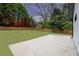 An expansive lawn and a concrete patio in a private backyard are enclosed by a wood fence and mature trees at 1934 Pinedale Pl, Decatur, GA 30032