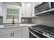 Modern kitchen with white cabinets and gray herringbone backsplash at 1934 Pinedale Pl, Decatur, GA 30032