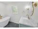 Bright bathroom with a soaking tub and vanity with a marble countertop and gold accents at 369 Antioch Rd, Dallas, GA 30157