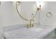 Bathroom with marble countertop, gold fixtures, and a large round mirror at 369 Antioch Rd, Dallas, GA 30157