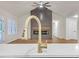 Close-up of a kitchen island with a gold faucet, white countertops, and a living room fireplace at 369 Antioch Rd, Dallas, GA 30157