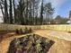 A beautiful backyard features a new fence, mulched beds with decorative plants, and a concrete patio at 799 River Gardens Se Dr, Atlanta, GA 30354