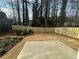 Newly fenced backyard with a concrete patio and mulched landscaping, offering a secure outdoor area at 799 River Gardens Se Dr, Atlanta, GA 30354