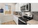 Modern kitchen features stainless steel appliances and gray tile backsplash at 799 River Gardens Se Dr, Atlanta, GA 30354