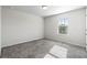 Simple bedroom with grey carpet and a single window at 4839 Dufour Dr, Lilburn, GA 30047