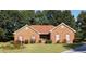 Charming brick home featuring a manicured lawn, symmetrical shrubbery, and tasteful landscaping at 2509 Fairweather Ct, Conyers, GA 30013