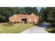 Beautiful brick home with a well-maintained lawn and attractive landscaping; long driveway to the side at 2509 Fairweather Ct, Conyers, GA 30013