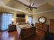 Relaxing main bedroom showcasing a tray ceiling, hardwood floors, and warm tones at 2509 Fairweather Ct, Conyers, GA 30013