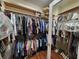 Organized walk-in closet with hardwood floors and clothing hanging from rods with shelving above at 2509 Fairweather Ct, Conyers, GA 30013
