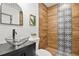 Modern bathroom with glass vessel sink, wood-look tile, and patterned accent wall at 2049 Meador Se Ave, Atlanta, GA 30315