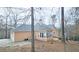 Tan house with two-car garage and a sunroom at 1050 Wiley Bridge Rd, Woodstock, GA 30188