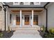 Brick porch with three wooden doors and white columns at 100 Percheron Dr, Canton, GA 30114