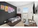 Well-lit bedroom with a twin bed, desk, and dark accent wall at 110 Cobalt Dr, Fayetteville, GA 30214