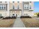 Two story townhome with light brick and white siding, welcoming porch and landscaping at 110 Cobalt Dr, Fayetteville, GA 30214