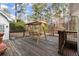 Relaxing back deck with a charming swing seat, surrounded by lush trees and serene atmosphere at 1579 Howell Highlands Dr, Stone Mountain, GA 30087