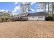 Large backyard view of the two-story home featuring a deck and attached garage at 1579 Howell Highlands Dr, Stone Mountain, GA 30087