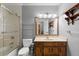 Bathroom featuring a classic vanity, toilet, and shower with a glass door at 1579 Howell Highlands Dr, Stone Mountain, GA 30087