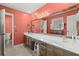 Primary bathroom with double vanity, wooden cabinets and coral paint at 1579 Howell Highlands Dr, Stone Mountain, GA 30087