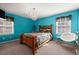 Vibrant bedroom with teal walls, chandelier, and ample natural light at 1579 Howell Highlands Dr, Stone Mountain, GA 30087