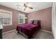 Cozy bedroom with plush carpeting, ceiling fan, and natural light from two windows at 1579 Howell Highlands Dr, Stone Mountain, GA 30087