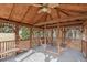 Cozy gazebo interior with ceiling fan, seating, and scenic views of the surrounding wooded landscape at 1579 Howell Highlands Dr, Stone Mountain, GA 30087