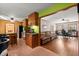 Open concept kitchen leading into living area with hardwood flooring, a leather couch and two desks at 1579 Howell Highlands Dr, Stone Mountain, GA 30087