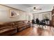 Cozy living room with hardwood floors, a brown leather sofa, and a ceiling fan at 1579 Howell Highlands Dr, Stone Mountain, GA 30087