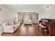 Bright living room with hardwood floors, white sofas, and a piano at 1579 Howell Highlands Dr, Stone Mountain, GA 30087