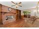 Living room with hard wood floors, a brick fireplace, built in shelves and a view of the kitchen at 1579 Howell Highlands Dr, Stone Mountain, GA 30087