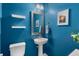 Small powder room with pedestal sink and blue walls at 1590 Ridgebrook Downs, Mableton, GA 30126