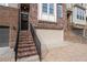 Brick front entry of a townhome with steps leading to a dark-colored door and attached garage at 2134 Old Georgian Nw Ter, Atlanta, GA 30318