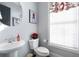 Small powder room with a pedestal sink, toilet, and window with blinds at 2134 Old Georgian Nw Ter, Atlanta, GA 30318