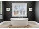 Spa-like bathroom featuring a freestanding soaking tub and dark wallpaper at 5220 Green Oak Ct, Atlanta, GA 30327