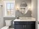 Elegant bathroom with dark vanity, patterned walls, and oval mirror at 5220 Green Oak Ct, Atlanta, GA 30327