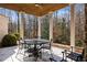 Covered patio with stone flooring, wooden ceiling beams, and outdoor dining furniture at 5220 Green Oak Ct, Atlanta, GA 30327