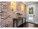 Inviting entryway with exposed brick wall, console table, and hardwood floors at 5220 Green Oak Ct, Atlanta, GA 30327