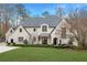 Elegant two-story home with white brick exterior, manicured lawn and gray roof at 5220 Green Oak Ct, Atlanta, GA 30327