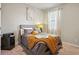 Cozy bedroom with gray upholstered bed, nightstand, and mustard blanket at 1508 Denver Way, Locust Grove, GA 30248