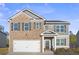 Two-story brick home with gray siding, a white garage door, and landscaping at 1508 Denver Way, Locust Grove, GA 30248