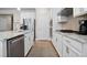 White kitchen cabinets, granite countertops and stainless steel appliances at 427 Bluffs View Ln, Canton, GA 30114