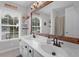 Bathroom with double vanity, white cabinets, and a rustic mirror at 615 Keeneland Ter, Woodstock, GA 30189