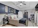 Serene bedroom with a gray upholstered bed and dark blue accent wall at 615 Keeneland Ter, Woodstock, GA 30189