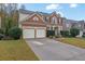 Two-story house with a brick facade, two-car garage, and well-maintained lawn at 615 Keeneland Ter, Woodstock, GA 30189