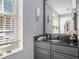 Bathroom vanity featuring granite countertop with a mirror reflecting light from a nearby window at 195 14Th Ne St # 902, Atlanta, GA 30309