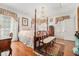 Sunlit main bedroom boasts a four-poster bed, chandelier, hardwood floors, and vintage-style decor at 7 W Andrews Nw Dr, Atlanta, GA 30305