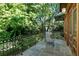 Charming balcony with stone tiles, metal railings, and wood-framed doors surrounded by greenery at 2220 Edison Ave, Atlanta, GA 30305