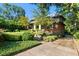 Stately brick home with arched portico, mature trees, and professionally landscaped yard with driveway at 2220 Edison Ave, Atlanta, GA 30305